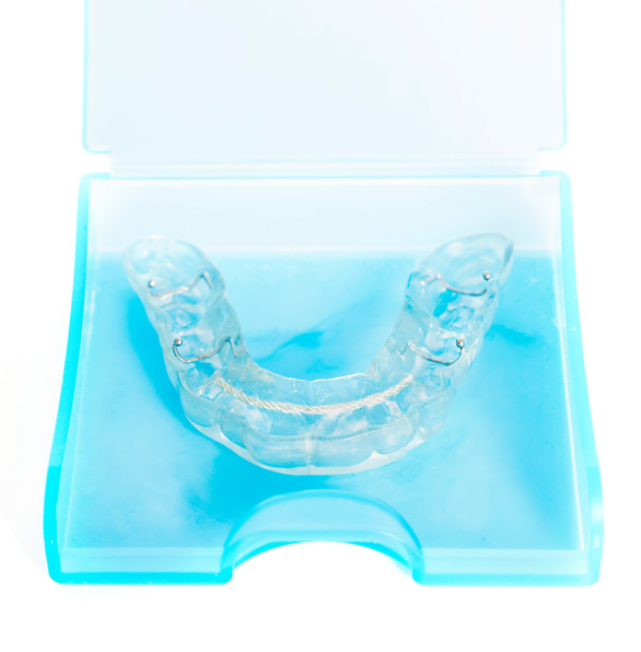An image of a clear nightguard from Excellent Dental Specialists in a light blue container.