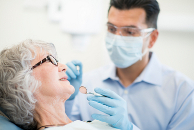 San Antonio dentist examine a patient after teeth in one day procedure at Excellent Dental Specialists.